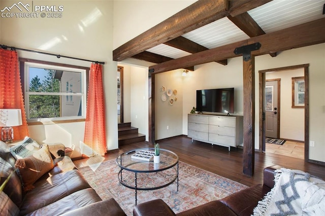 living area with baseboards, hardwood / wood-style floors, stairway, and beamed ceiling