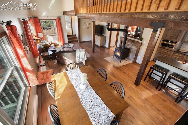 dining space with stairway, a wood stove, and hardwood / wood-style flooring