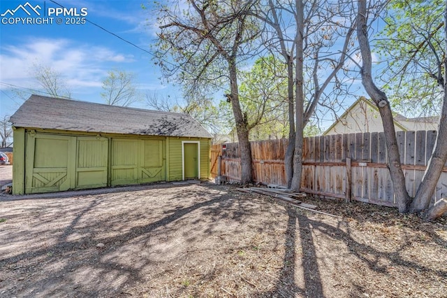 view of yard featuring fence, an outbuilding, and a storage unit