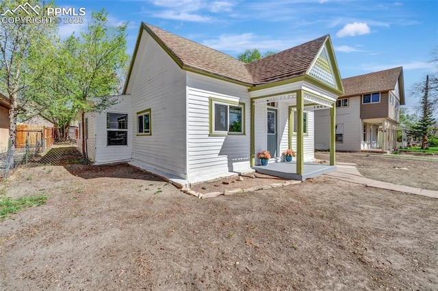 rear view of property featuring fence