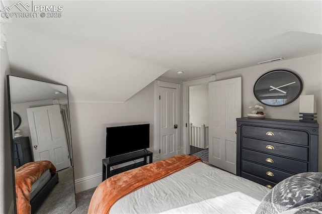carpeted bedroom with visible vents, baseboards, and lofted ceiling
