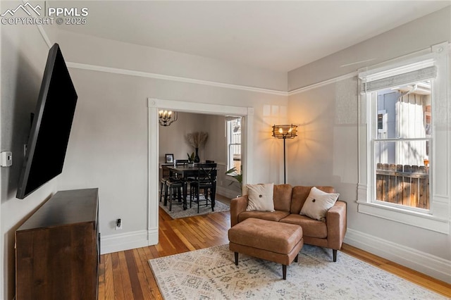 living room with baseboards, wood finished floors, and a chandelier