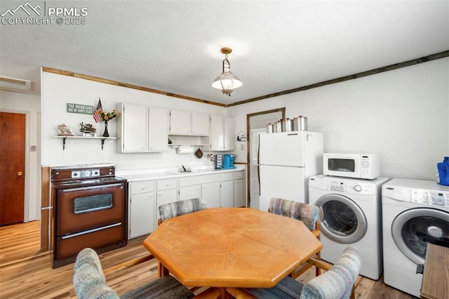 kitchen featuring open shelves, white appliances, light wood-style floors, washer and clothes dryer, and light countertops