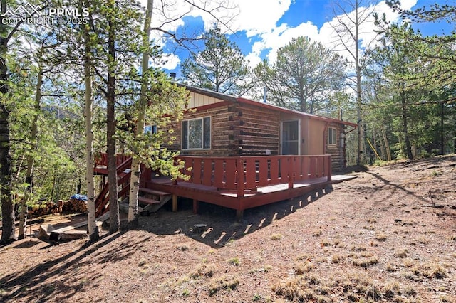 view of property exterior with a wooden deck and log exterior