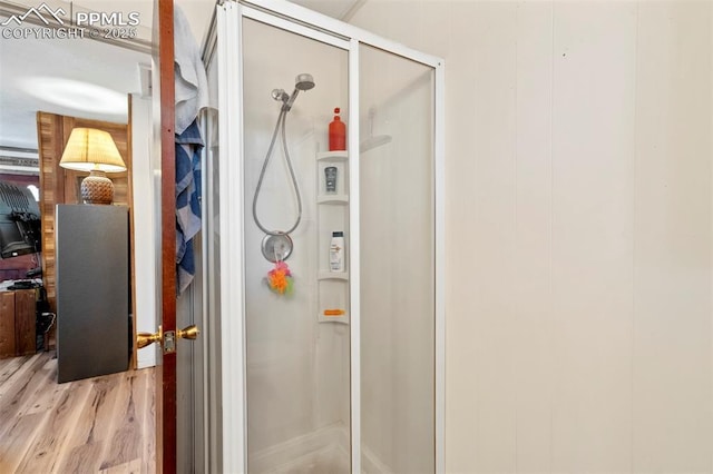 full bath featuring wood finished floors and a stall shower