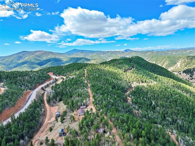 aerial view featuring a forest view and a mountain view