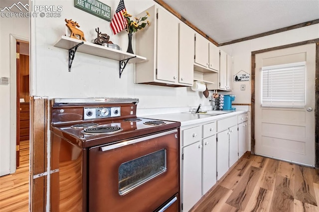 kitchen with open shelves, range with electric cooktop, a sink, and light wood-style flooring