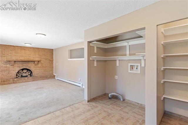 1187 Willow Bend Cir Unit A # 4, Colorado Springs, CO 80918 - washroom with a baseboard radiator, carpet, a textured ceiling, a fireplace, and washer hookup