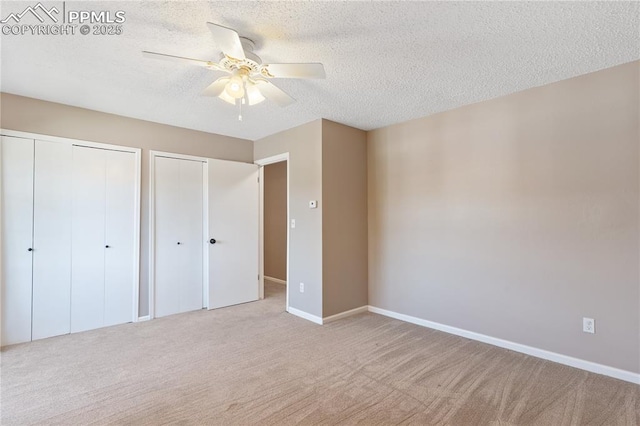 1187 Willow Bend Cir Unit A # 4, Colorado Springs, CO 80918 - unfurnished bedroom with multiple closets, carpet flooring, a textured ceiling, and a ceiling fan