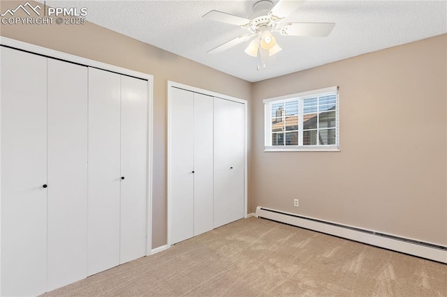 1187 Willow Bend Cir Unit A # 4, Colorado Springs, CO 80918 - unfurnished bedroom with a baseboard radiator, light carpet, two closets, ceiling fan, and a textured ceiling