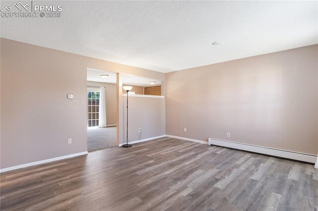 1187 Willow Bend Cir Unit A # 4, Colorado Springs, CO 80918 - empty room with a baseboard heating unit, wood finished floors, and a textured ceiling