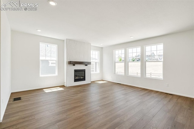 1821 Water Birch Way, Castle Rock, CO 80108 - unfurnished living room with a wealth of natural light, visible vents, wood finished floors, and a fireplace