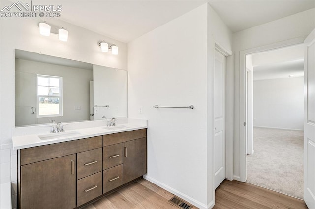 1821 Water Birch Way, Castle Rock, CO 80108 - bathroom with double vanity, a sink, wood finished floors, and visible vents