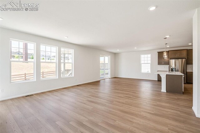 1821 Water Birch Way, Castle Rock, CO 80108 - unfurnished living room with visible vents, baseboards, recessed lighting, and light wood-type flooring