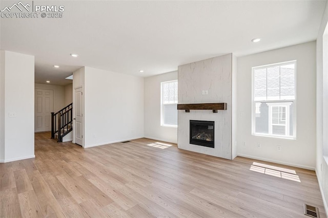 1821 Water Birch Way, Castle Rock, CO 80108 - unfurnished living room featuring stairway, light wood finished floors, a large fireplace, visible vents, and recessed lighting