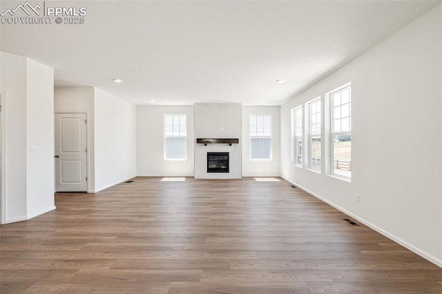 1821 Water Birch Way, Castle Rock, CO 80108 - unfurnished living room with recessed lighting, baseboards, a large fireplace, visible vents, and wood finished floors