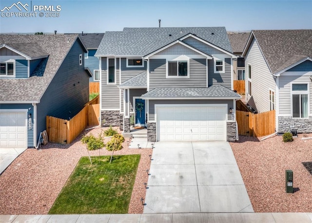 view of front facade featuring fence, an attached garage, stone siding, driveway, and a shingled roof