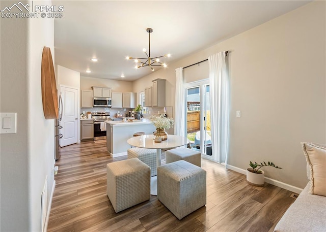 dining room featuring light wood finished floors, baseboards, recessed lighting, and an inviting chandelier