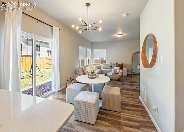 dining room with a wealth of natural light, a notable chandelier, and wood finished floors