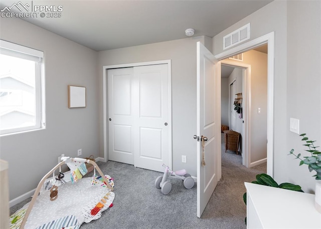 carpeted bedroom featuring baseboards, a closet, and visible vents