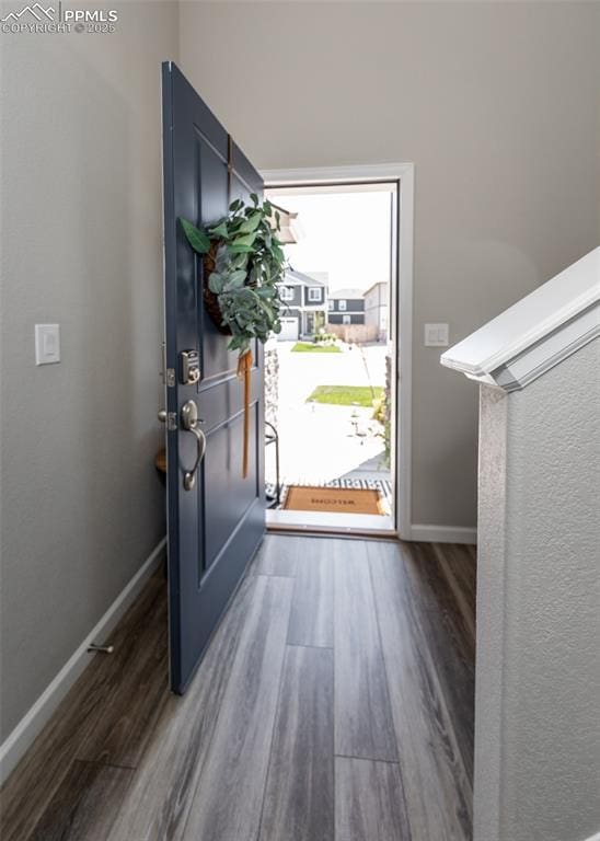 entryway featuring baseboards and wood finished floors