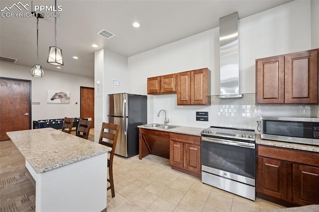 10713 Traders Pkwy, Fountain, CO 80817 - kitchen featuring wall chimney range hood, a sink, appliances with stainless steel finishes, visible vents, and hanging light fixtures
