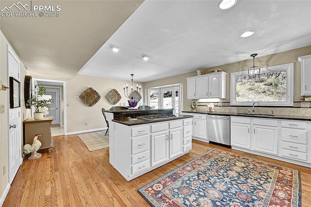 kitchen with stainless steel appliances, a chandelier, a sink, dark countertops, and recessed lighting