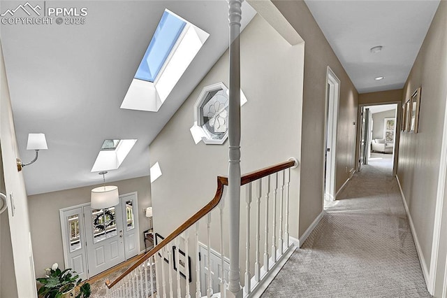 corridor with a skylight, carpet floors, and baseboards