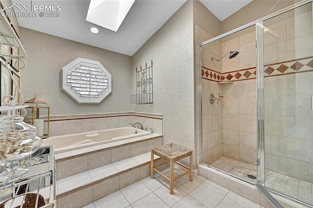 full bathroom featuring a textured wall, a skylight, a shower stall, and tile patterned flooring