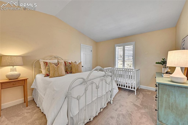 bedroom featuring light colored carpet, vaulted ceiling, and baseboards