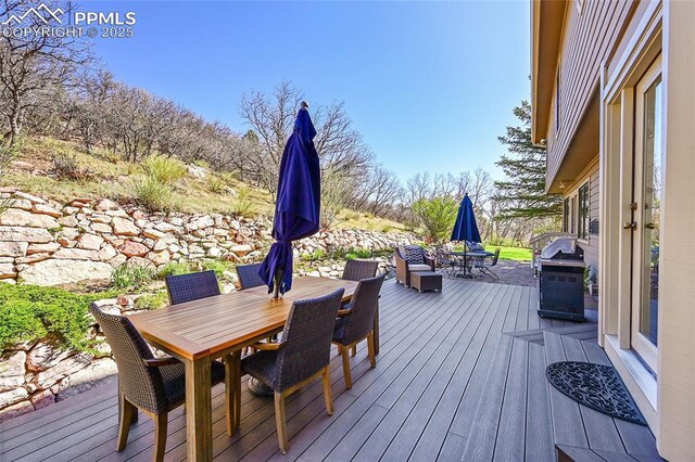 wooden deck featuring outdoor dining area and grilling area