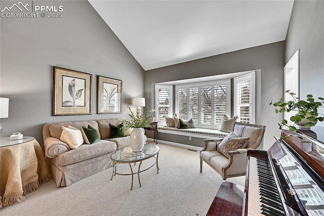 carpeted living room with high vaulted ceiling and baseboards