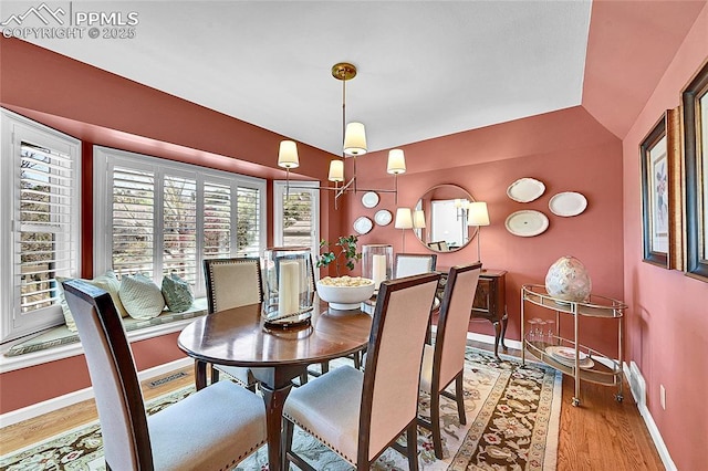 dining area with baseboards and wood finished floors