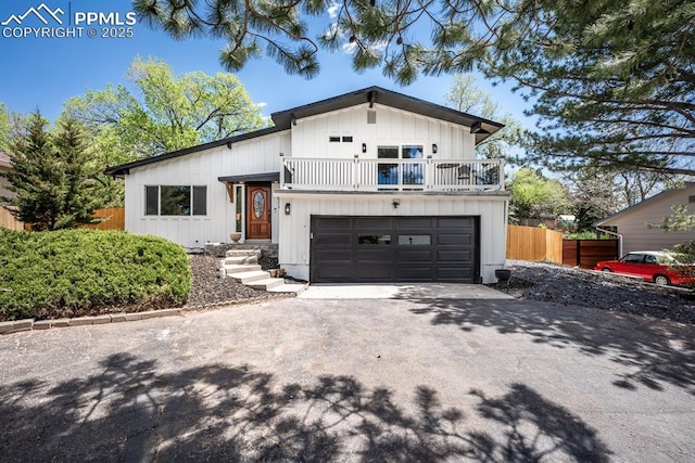 1021 Pioneer Ln, Colorado Springs, CO 80904 - view of front of property with a balcony, driveway, fence, an attached garage, and board and batten siding