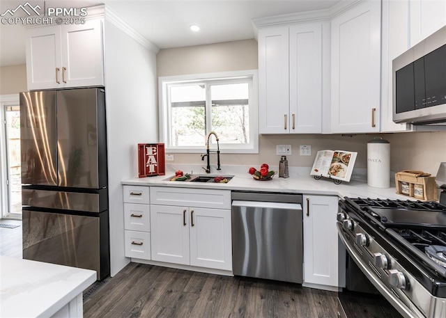 1021 Pioneer Ln, Colorado Springs, CO 80904 - kitchen featuring appliances with stainless steel finishes, a sink, white cabinetry, dark wood-style floors, and recessed lighting