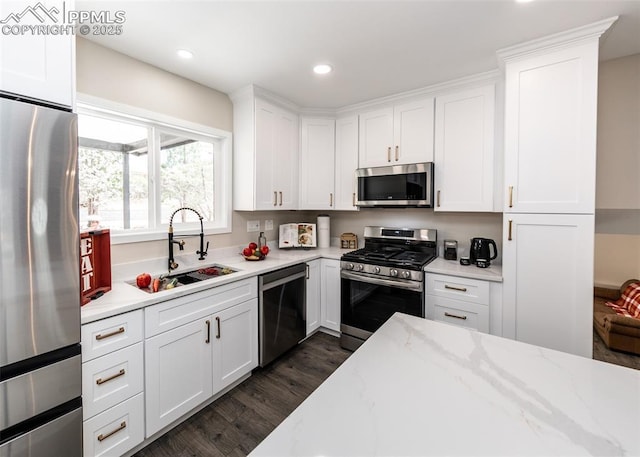 1021 Pioneer Ln, Colorado Springs, CO 80904 - kitchen with stainless steel appliances, a sink, dark wood-style floors, white cabinetry, and recessed lighting