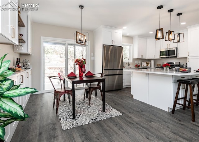 1021 Pioneer Ln, Colorado Springs, CO 80904 - kitchen with stainless steel appliances, a chandelier, light countertops, dark wood finished floors, and recessed lighting