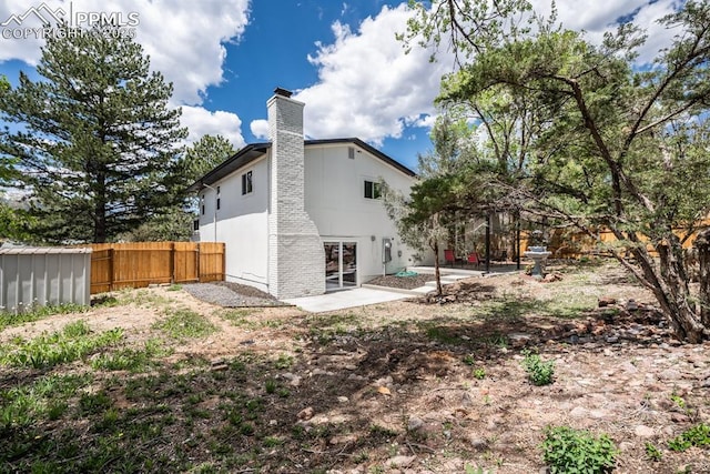 1021 Pioneer Ln, Colorado Springs, CO 80904 - back of property featuring fence, a chimney, and a patio