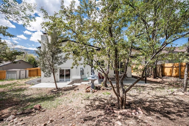 1021 Pioneer Ln, Colorado Springs, CO 80904 - rear view of property featuring a patio, a shed, a fenced backyard, and an outbuilding