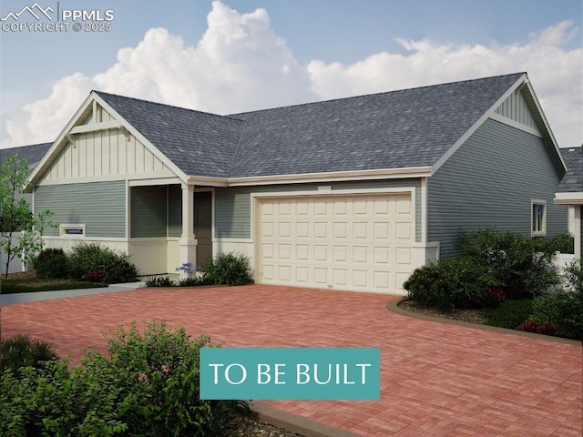 view of front of home with board and batten siding, an attached garage, a shingled roof, and decorative driveway