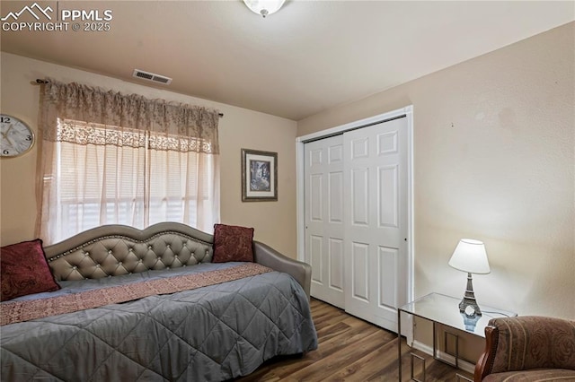 bedroom with wood finished floors, a closet, and visible vents