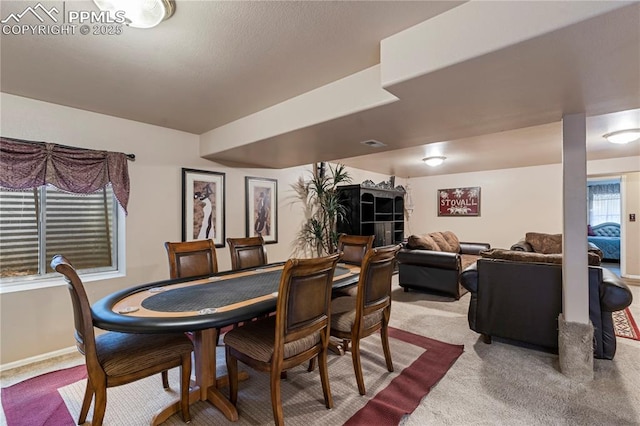 carpeted dining room featuring baseboards and visible vents