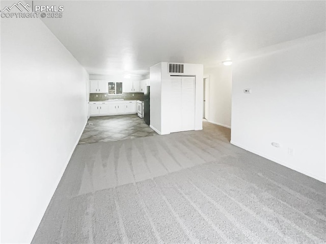 unfurnished living room featuring carpet flooring and visible vents