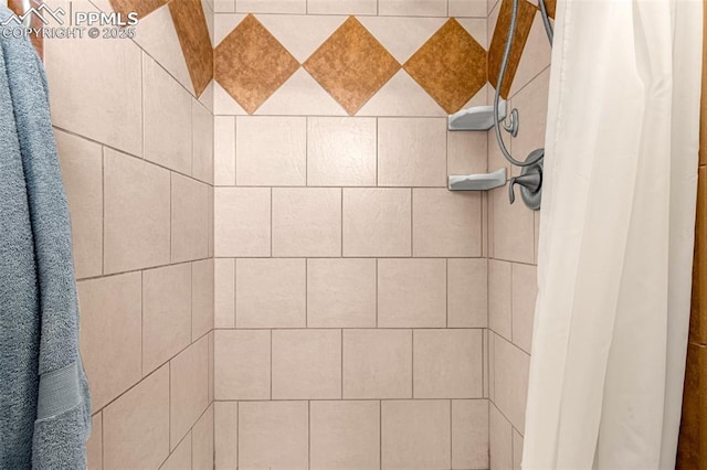 interior details featuring a tile shower