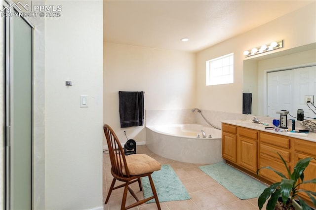 full bath featuring a garden tub, vanity, and tile patterned flooring