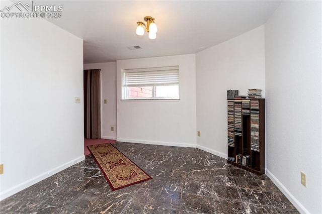 empty room featuring marble finish floor, baseboards, and visible vents