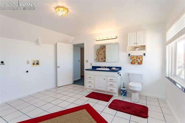 bathroom featuring toilet, vanity, baseboards, and tile patterned flooring