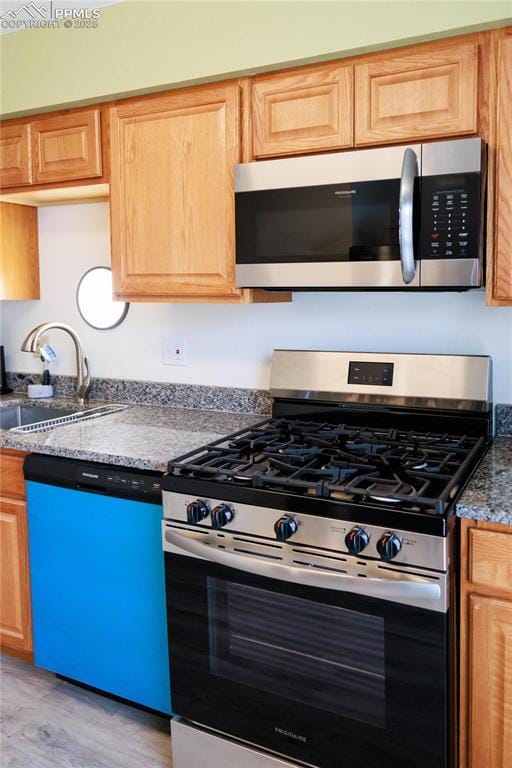 kitchen featuring a sink, appliances with stainless steel finishes, and light wood-style floors