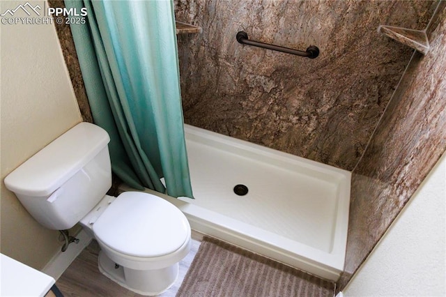 bathroom with toilet and a shower stall