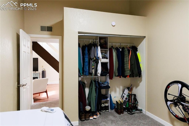 carpeted bedroom featuring baseboards, visible vents, and a closet